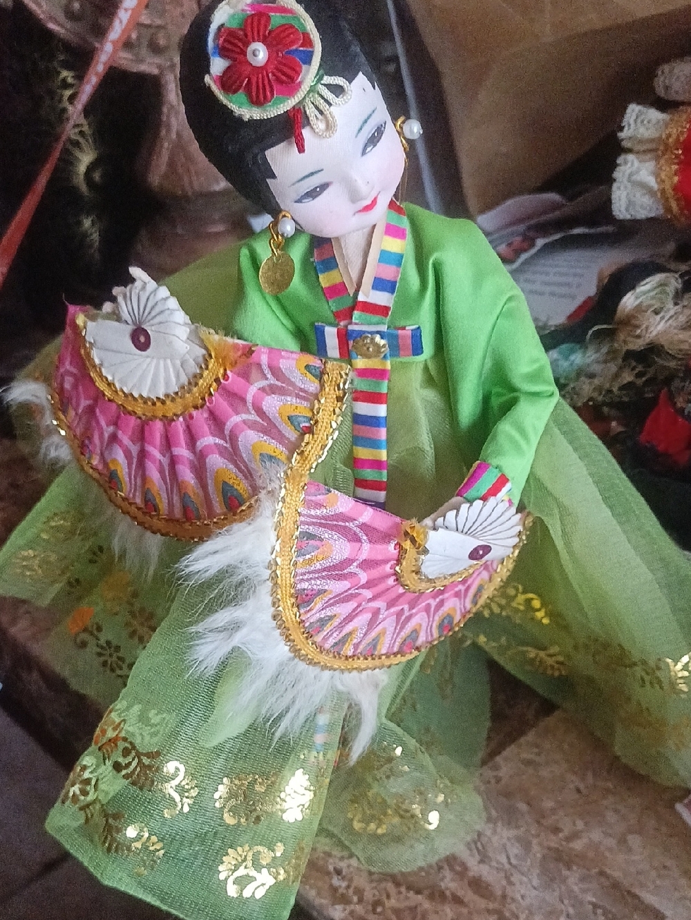vintage Korean fan dance doll dressed in a traditional hanbok costume and holdin